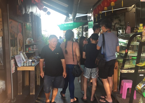 Clan Jetties: A photo of tourists and locals conversing and buying snacks at one of the business outlets.