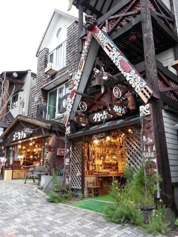 Manhole: An Ainu traditional craft shop with an elaborate wooden structure atop the entrance.