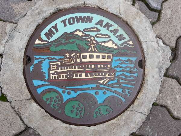 Manhole: Lake Akan's colourful manhole cover depicting its famous cruise, Mount Okan and marimo (green algae balls).