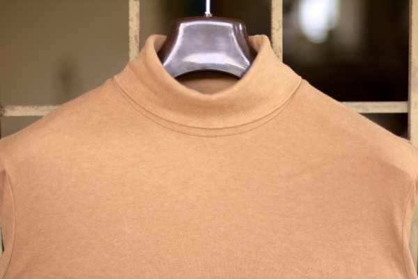 Solid medium brown roll-neck on a hanger.