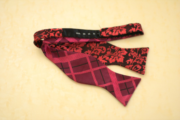 Close up of a self-tie bow tie, laid flat on the table, showcasing the adjustable neckband 