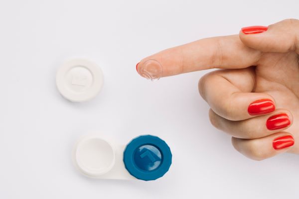 Woman holding up contact lenses