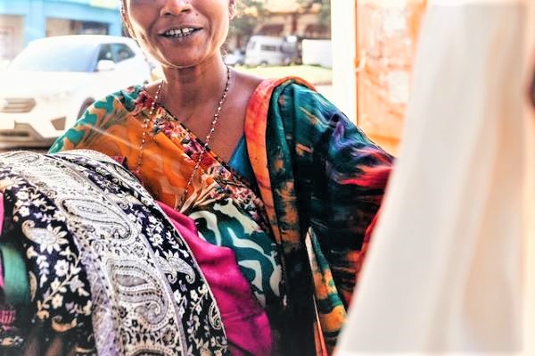 A smiling woman wearing a colourful saree.