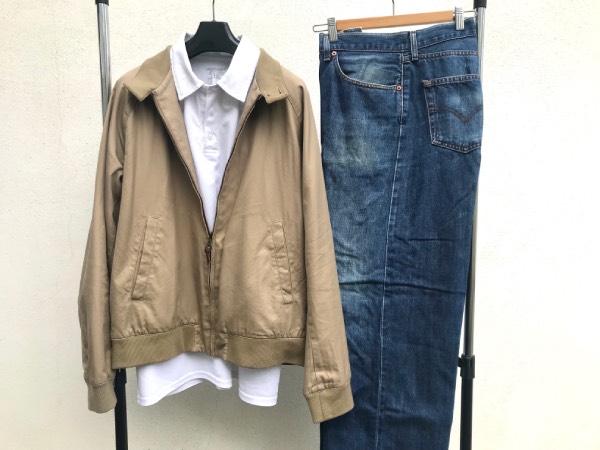Tan coloured Harrington jacket, white Polo shirt, and medium wash jeans.