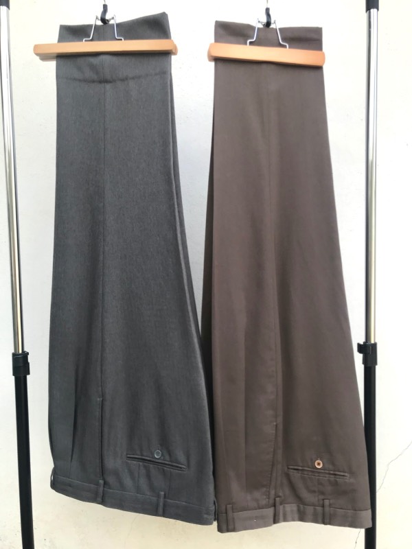 Two pairs of foundation dress trousers, one medium grey, and the other medium brown.