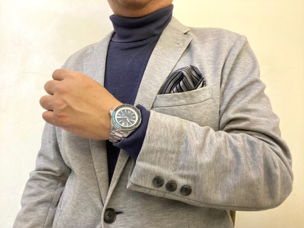 Light grey knit jacket, with a plain dark blue/grey roll-neck jumper, paired with the Ocean 2 diver.