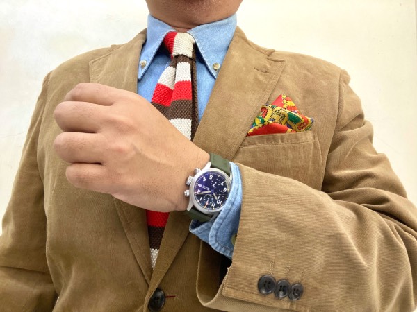 Unstructured, corduroy sport jacket in camel colour. Blue denim shirt in OCBD construction, with a knit tie in segments of brown, red and off-white. And the ML1868 field watch with olive green sailcloth strap.