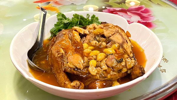 Eight Treasure Chicken, a traditional Hakka dish, served on a large flat bowl.