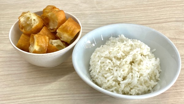 A bowl of white rice, and a bowl of youtiao, cut into blocks.