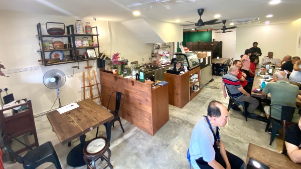 A wide-angle view of the interior of Sri Nyonya Bistro, showing the layout of the dining area, together with the counter, and the 